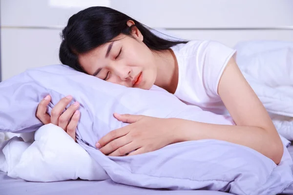Kvinna som sover på säng i sovrummet — Stockfoto
