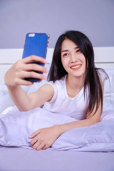 Femme prenant selfie sur lit dans la chambre — Photo