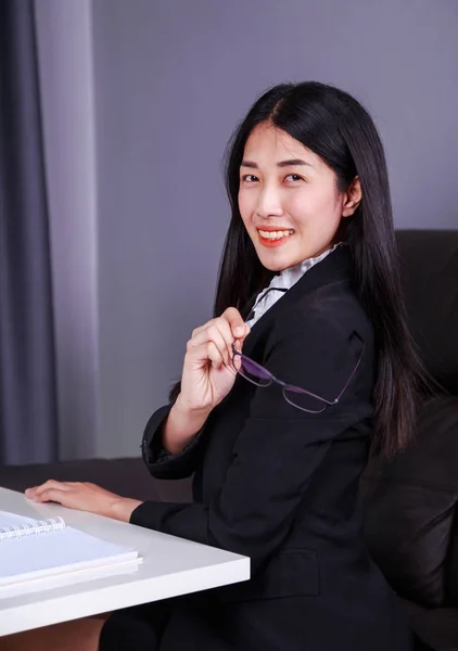 Glückliche Geschäftsfrau sitzt am Schreibtisch — Stockfoto