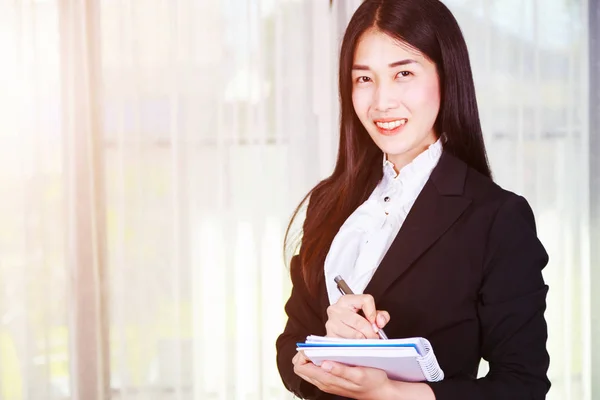 Mujeres de negocios de pie y anotando en el cuaderno —  Fotos de Stock