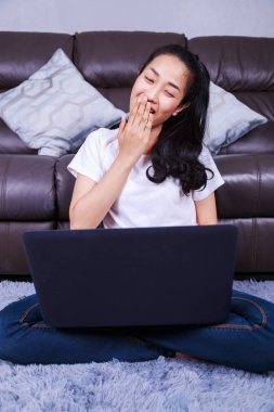 genç kadın evde oturma odasında bir dizüstü bilgisayar kullanarak