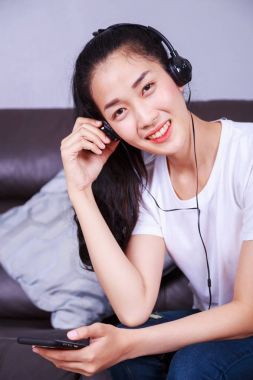 genç kadın moblie Divan kulaklıklarla müzik