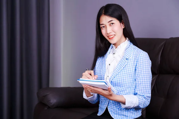 Biznes kobieta siedzi przy biurku i pisze notatkę na Uwaga — Zdjęcie stockowe