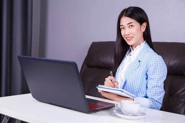 Business woman working with laptop computer and writes a journal — Stock Photo, Image