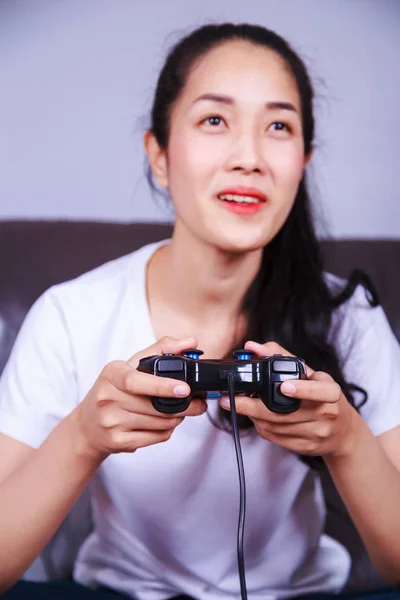 Mujer usando controlador de joystick jugando videojuego en el sofá en li — Foto de Stock