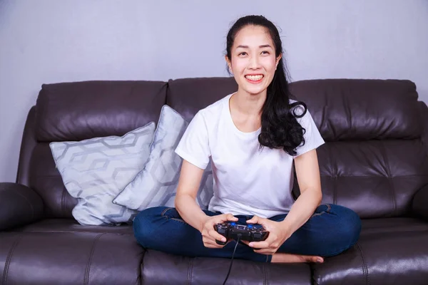 Mujer usando controlador de joystick jugando videojuego en el sofá en li — Foto de Stock