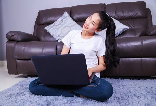 Młoda kobieta w salonie w domu za pomocą komputera przenośnego — Zdjęcie stockowe
