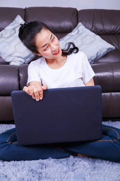 Jeune femme utilisant un ordinateur portable dans le salon à la maison — Photo
