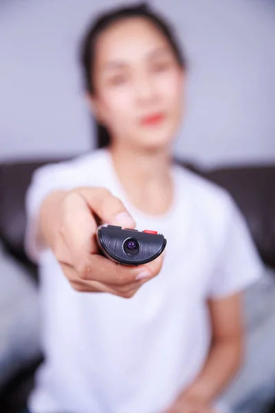 Mulher com tv controle remoto no sofá em casa — Fotografia de Stock