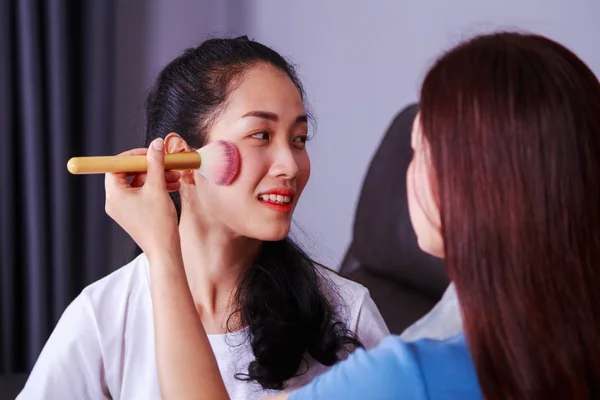 Woman using brush makeup on face her friend — Stock Photo, Image