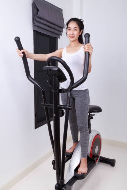 Sportif kadın eliptik eğitmen ile yapıyor