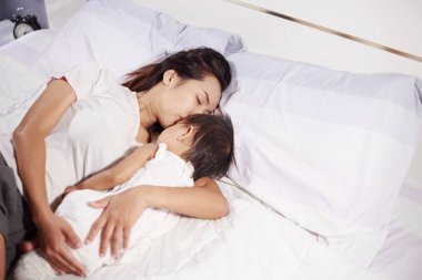 Anne ve evde yatakta uyuyan bebek