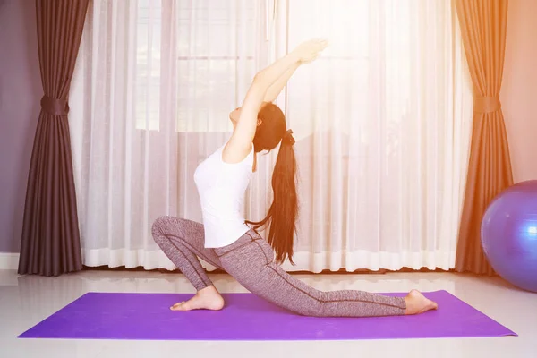 Žena, která dělá jógu výkonu izolovaných na bílém pozadí — Stock fotografie