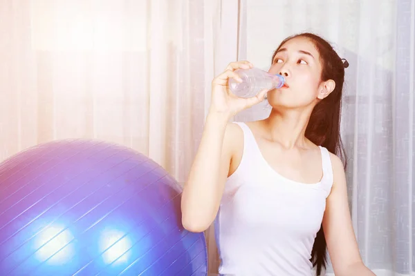 健身球运动后妇女喝水 — 图库照片