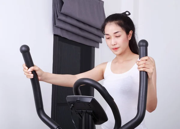 Sportig kvinna gör övningar med elliptical tränad — Stockfoto