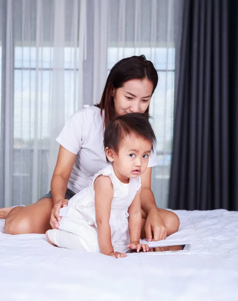 Mother and baby are looking to play and read tablet computer at — Stock Photo, Image