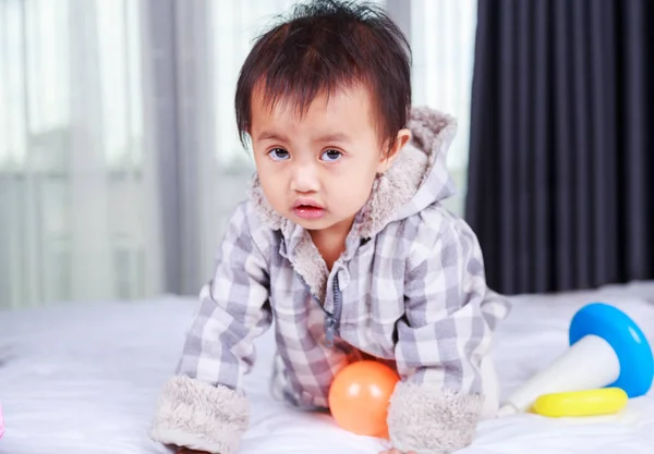 Ребенок играет с игрушкой на кровати — стоковое фото