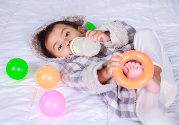 아기 침대에 병으로 우유를 마시는 — 스톡 사진