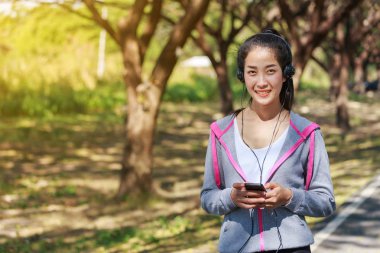 kulaklık Park ile akıllı telefon kullanan genç sportif kadın