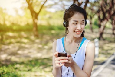 kulaklık Park ile akıllı telefon kullanan genç sportif kadın