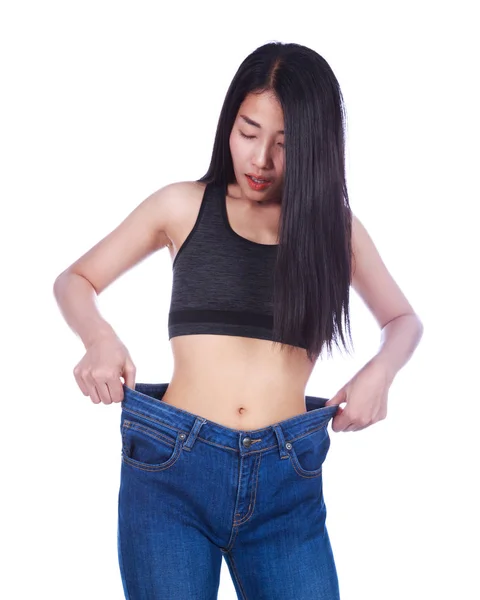 Shocked slim fitness woman in old jeans after losing weight isol — Stock Photo, Image