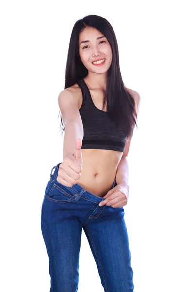Mulher magra em jeans velhos mostrando polegares isolados nas costas brancas — Fotografia de Stock