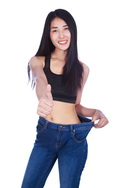 Slim woman in old jeans showing thumbs up isolated on white back — Stock Photo, Image