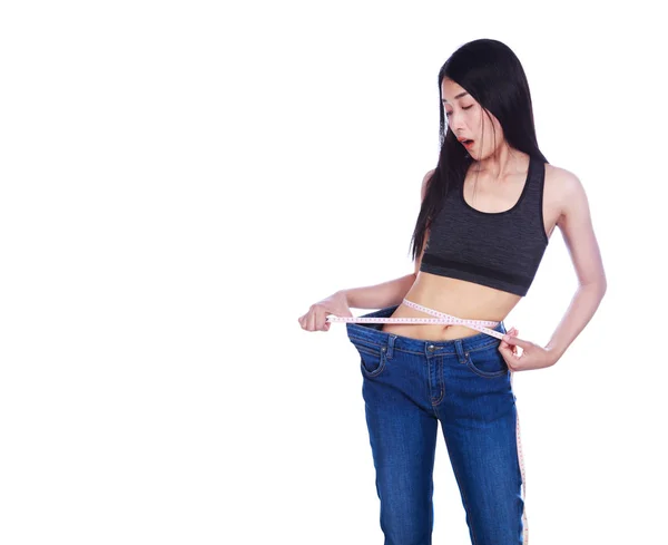 Shocked slim fitness woman in old jeans and measuring tape after — Stock Photo, Image