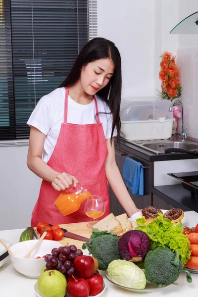 Dona de casa com derramamento de suco de laranja jar na sala de cozinha — Fotografia de Stock