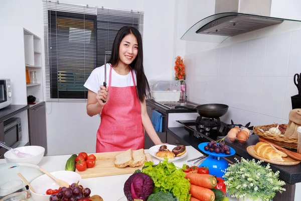Mulher segurando uma faca na sala de cozinha — Fotografia de Stock