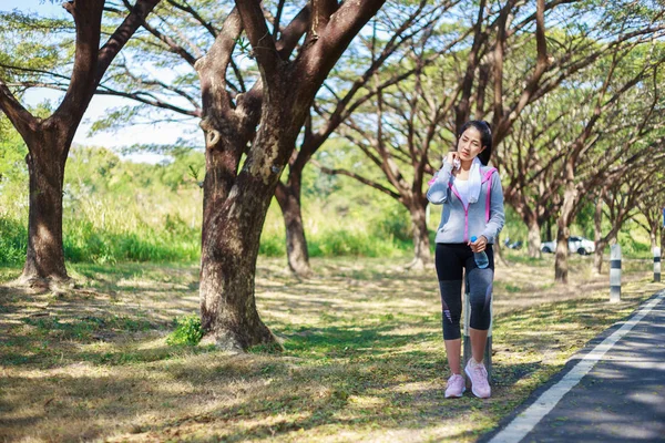 Mujer deportiva descansando y limpiando su sudor con una toalla después de la varita — Foto de Stock