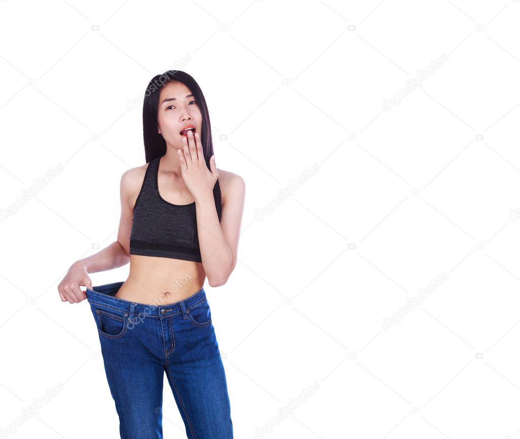 Shocked slim fitness woman in old jeans after losing weight isol