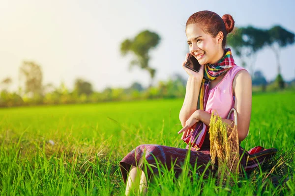 Farmer woman calling on the mobile phone in a rice field — Stock Photo, Image