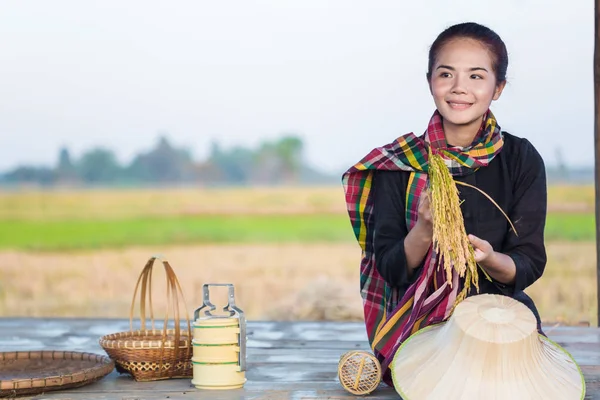 Campesina sosteniendo arroz y sentada en casa de campo en el campo de arroz —  Fotos de Stock