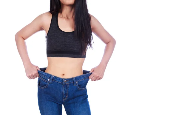 Close up van vrouw Toon haar verlies van het gewicht en het dragen van haar oude jeans — Stockfoto