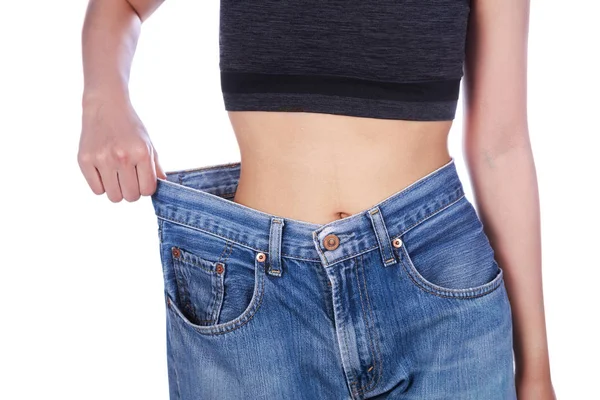 Nahaufnahme einer Frau, die ihren Gewichtsverlust zeigt und ihre alten Jeans trägt — Stockfoto
