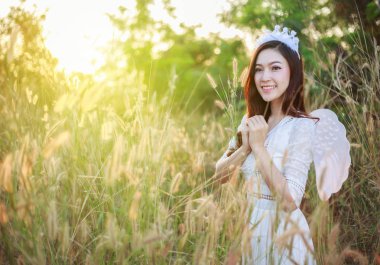 bir çim alan güneş ışığı ile melek kadın