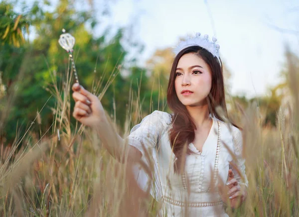 Mulher anjo em um campo de grama com luz solar — Fotografia de Stock