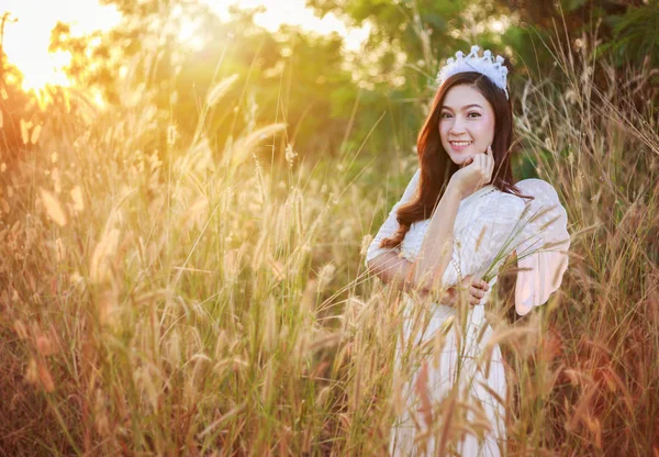 Mulher anjo em um campo de grama com luz solar — Fotografia de Stock