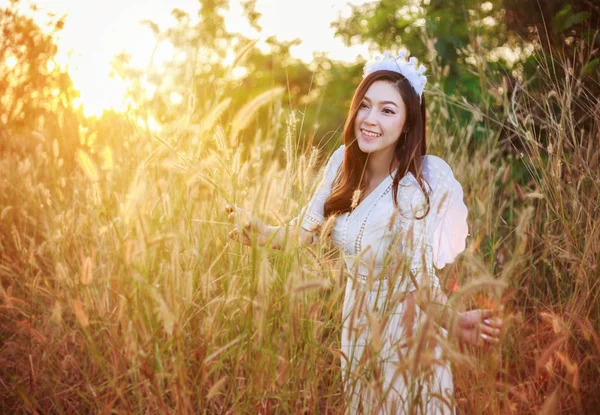 Mulher anjo em um campo de grama com luz solar — Fotografia de Stock