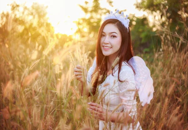 Angel woman in a grass field with sunlight — Stock Photo, Image