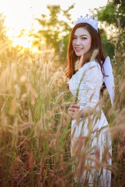 Ange femme dans un champ d'herbe avec la lumière du soleil — Photo