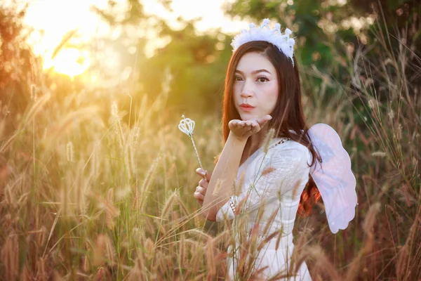 Ángel mujer en un campo de hierba con la luz del sol — Foto de Stock