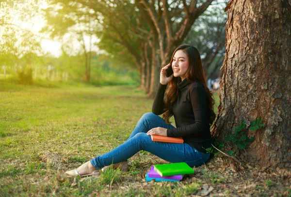 Smiling woman talking on mobile phone in park — Stock Photo, Image