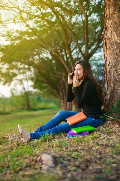 Glada kvinna talar på mobiltelefon i parken — Stockfoto