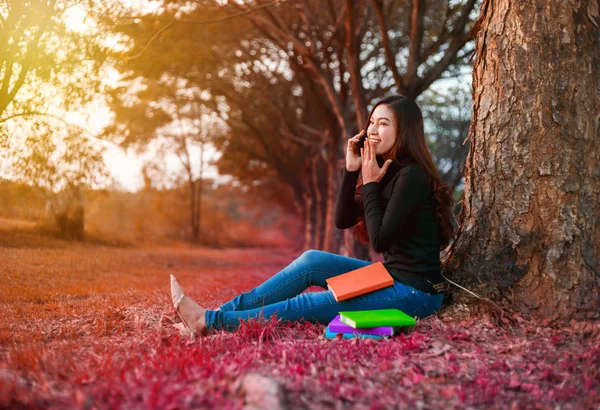 Glada kvinna talar på mobiltelefon i parken — Stockfoto