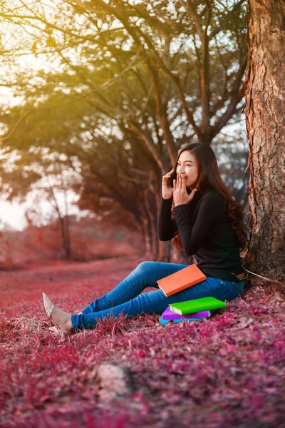 Cheerful woman talking on mobile phone in park — Stock Photo, Image