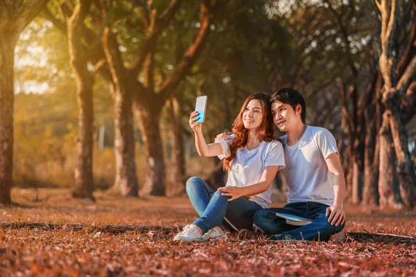 Couple utilisant un téléphone portable prenant un selfie dans le parc — Photo