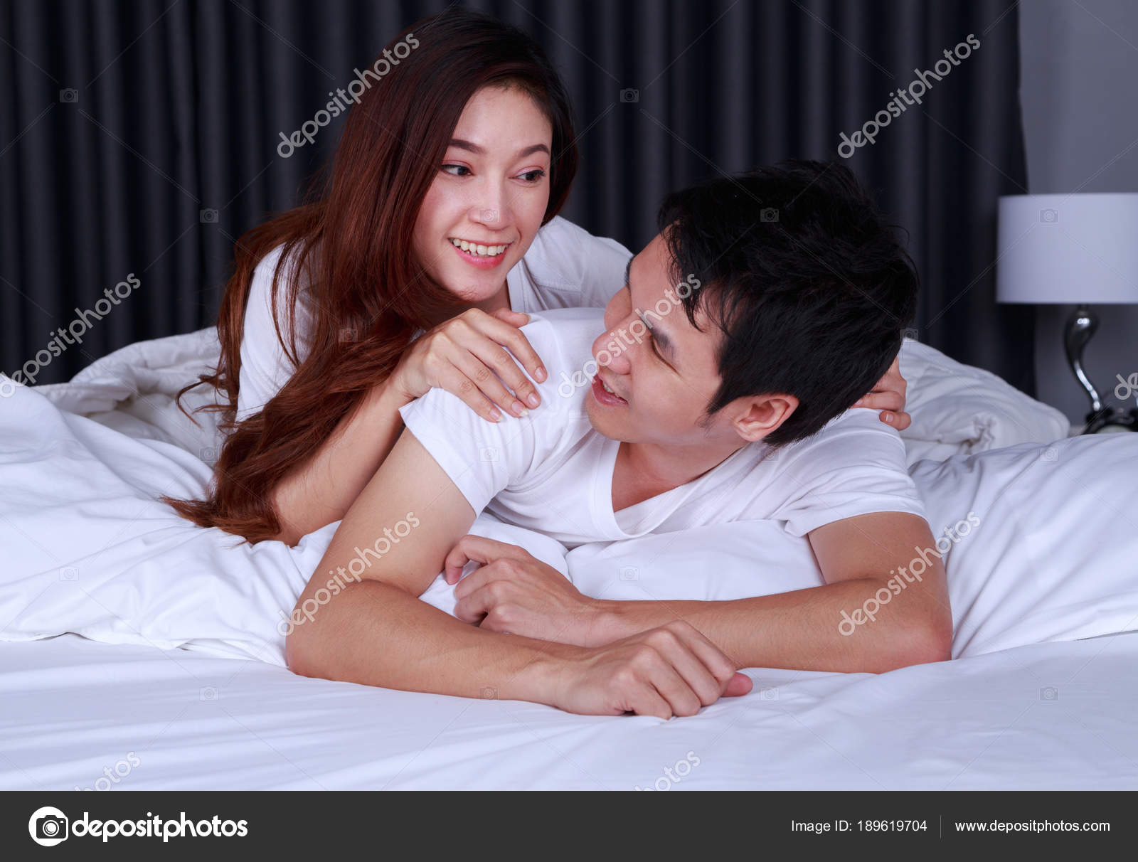 Happy Young Attractive Couple Hugging On Bed In Bedroom