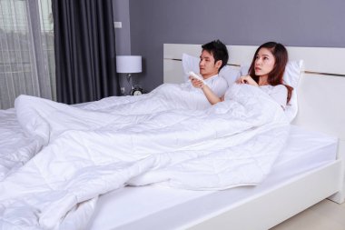 Genç çift Klima, uzaktan kumandalı bir yatakta yatarken